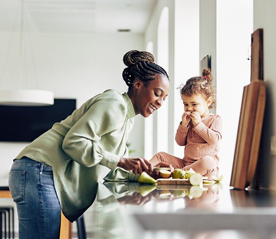 Mother and child eating snack together in kitchen