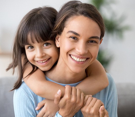 Mom and daughter smiling together