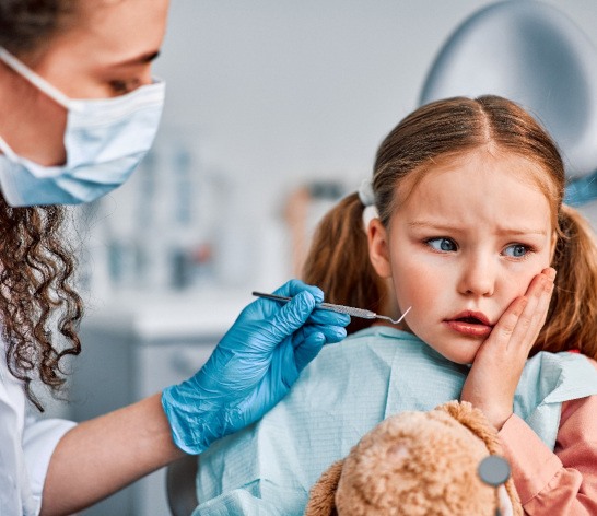 Child patient in Canton holding cheek due to dental emergencies