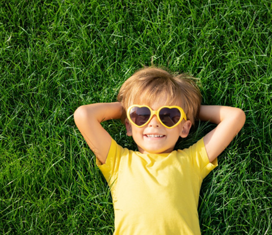 Happy child reclining on grass
